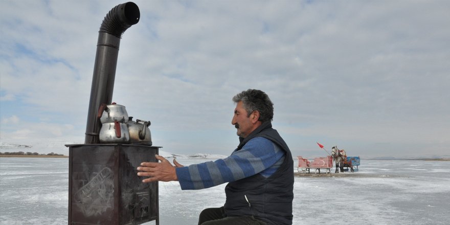 Donan Çıldır Gölü üzerinde soba yakıp çay demliyor