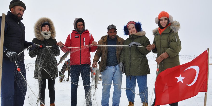 Köylü gençler misafirlere Eskimo usulü balık tutturuyor